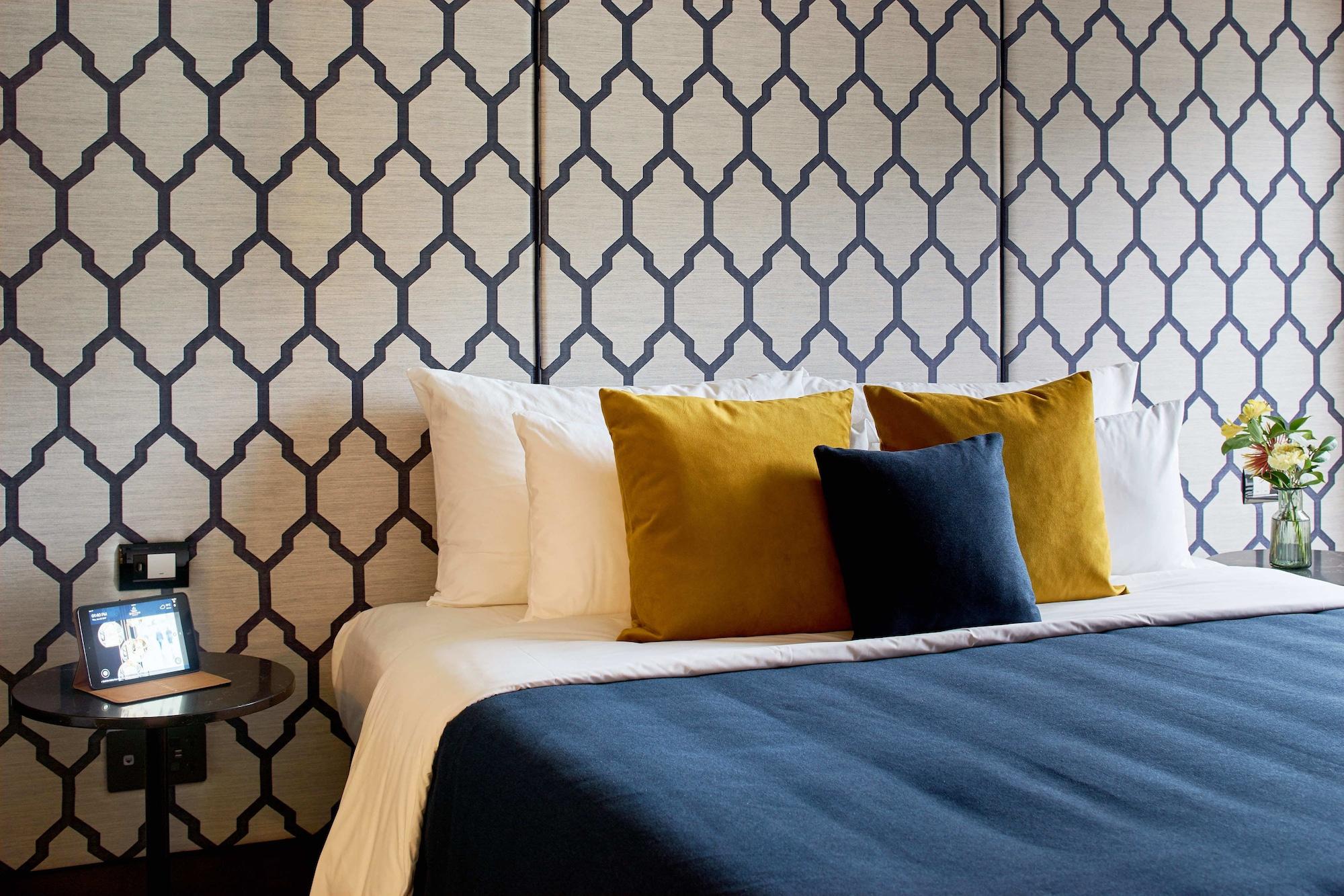 Bolton Hotel Wellington Bagian luar foto A bed with cushions